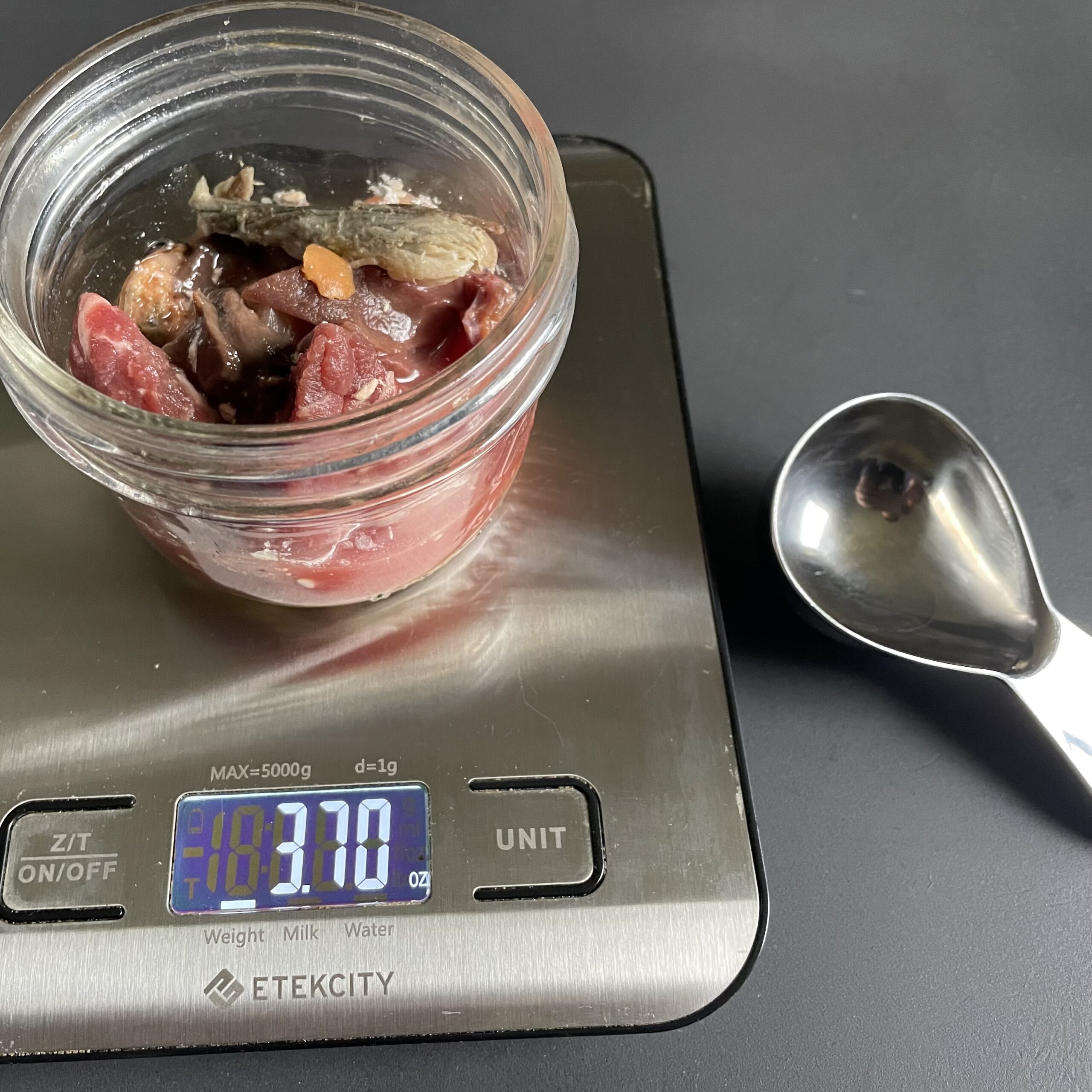 weighing how much food on scale with measuring scoop